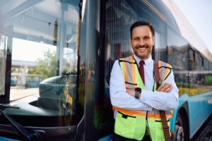 Happy city bus driver at the station looking at camera.